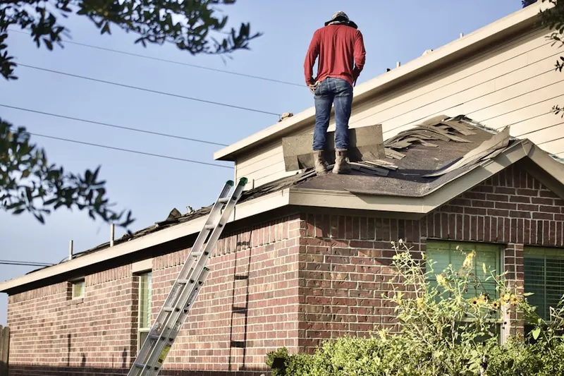 Professional roofer working on a residential roof in Oakridge Place